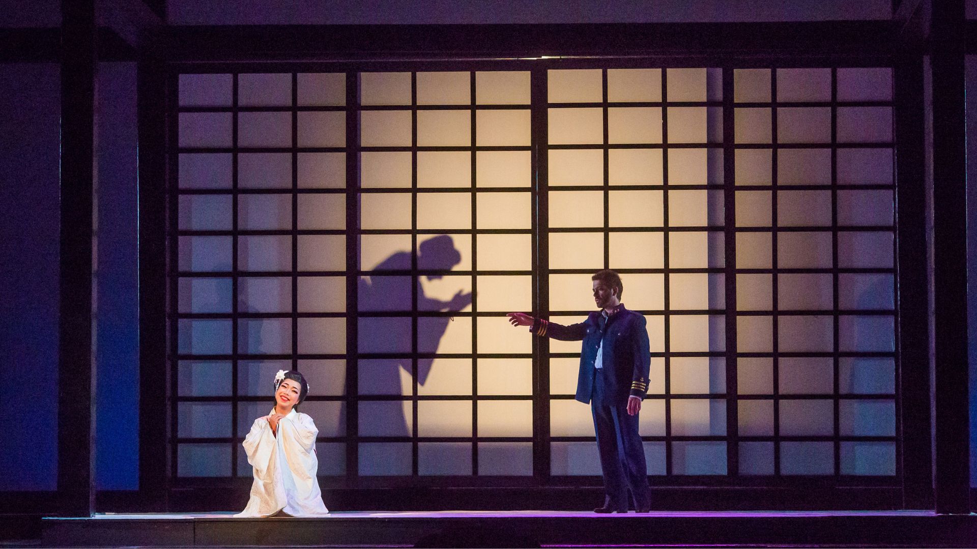 Scènefoto van Madame Butterfly keizerin knielt in wit gewaad.