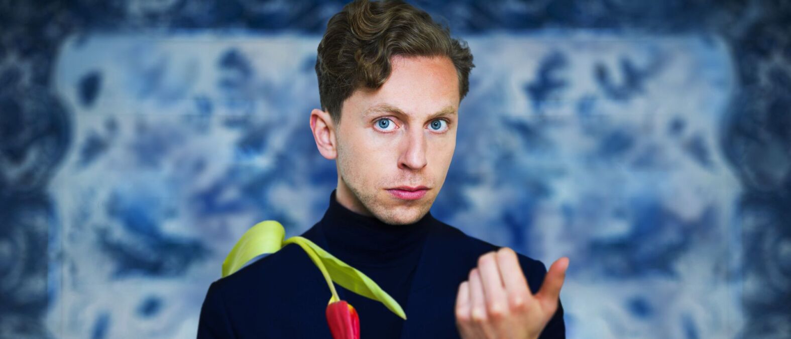 Boban kijkt de camera in. Er hangt een tulp over zijn schouder.