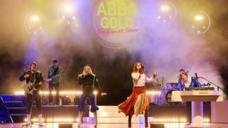 2 mannen en 2 vrouwen verkleed als de leden van ABBA op een podium