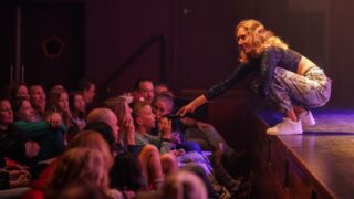 Interactie met kinderen in de zaal vanaf podium