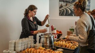 Horecamedewerkster schenkt soep in aan een buffet