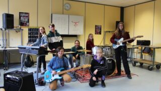 Schoolband met jongeren die achter hun instrument zitten