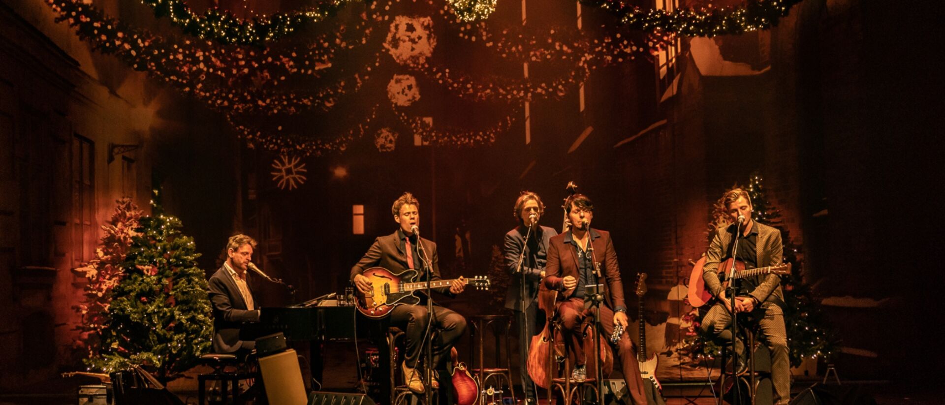 de 3JS die zingen met op de achtergrond allemaal kerstversiering.