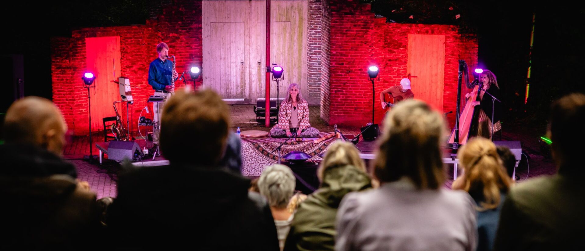 Performer zit in meditatie op podium tijdens Yoga in Concert Hoorn