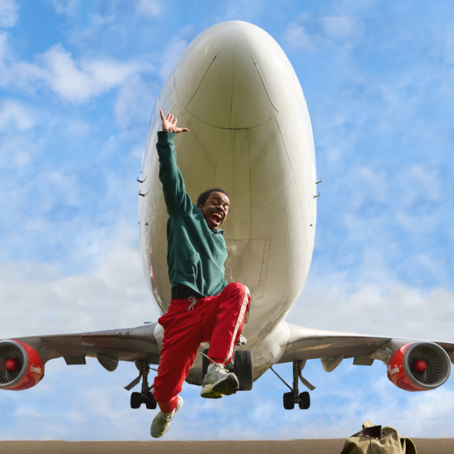 Een danser springt omhoog met een opstijgend vliegtuig in de achtergrond