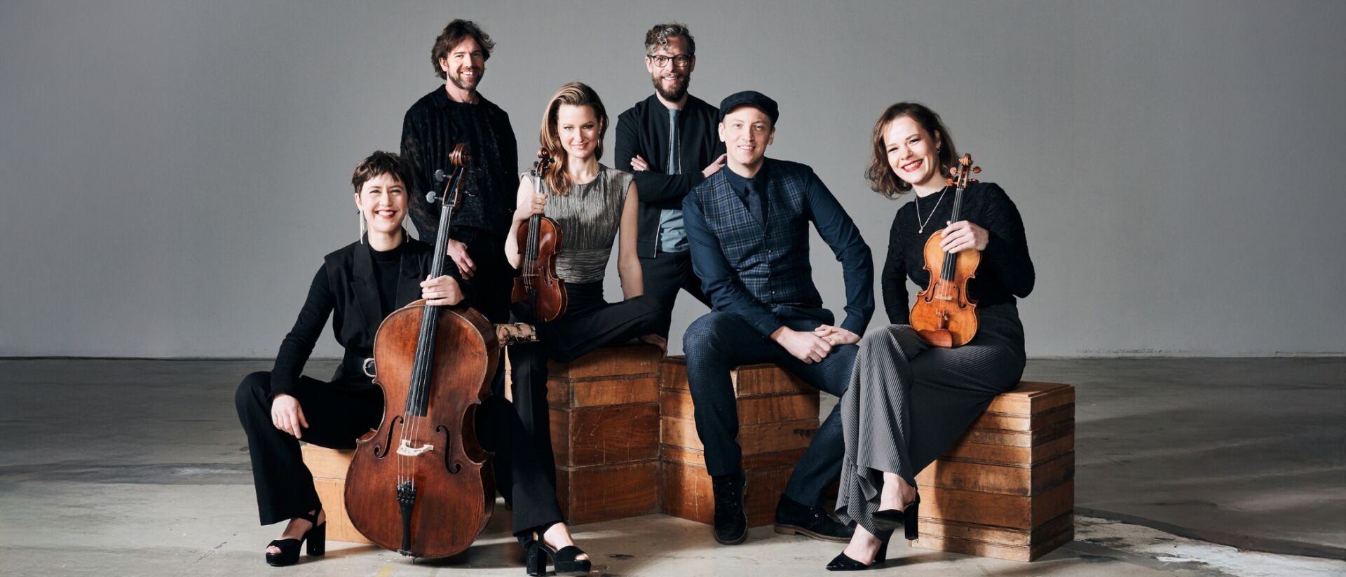 Zes personen die instrumenten vasthouden en kijken in de camera.