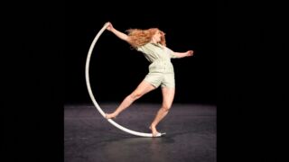Acrobate in halve cirkel dansend op vloer