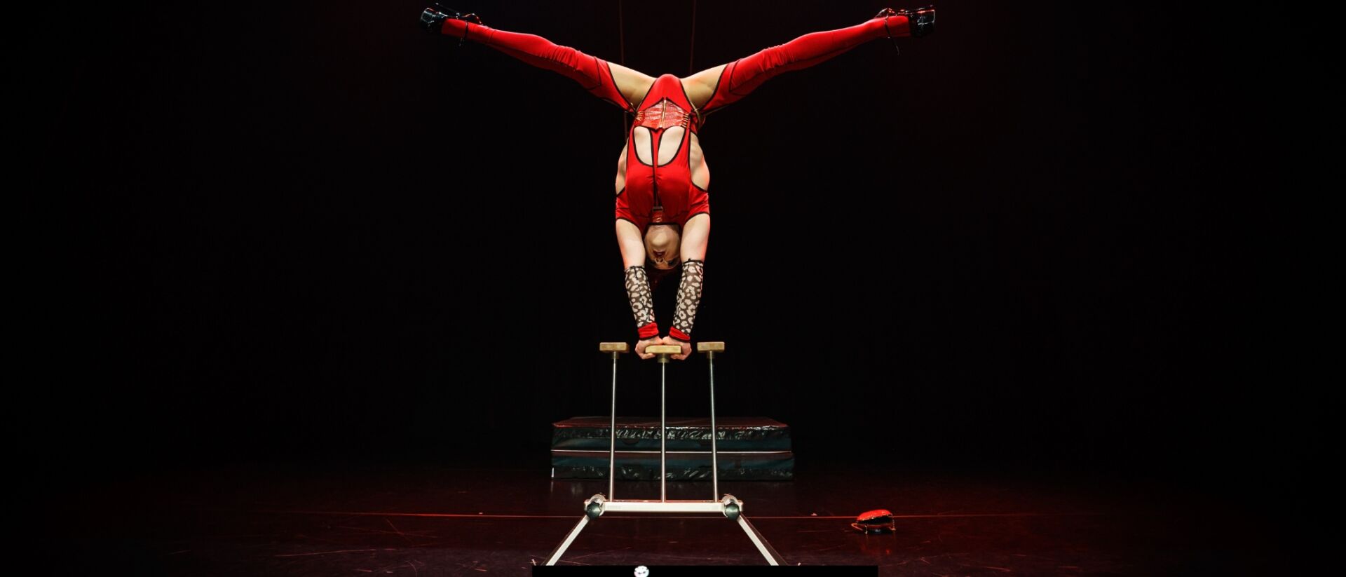 Acrobate in rood pakje op z'n kop
