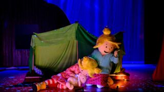 Zoete zusjes in de nacht (in donkere zaal) met een tent op de achtergrond