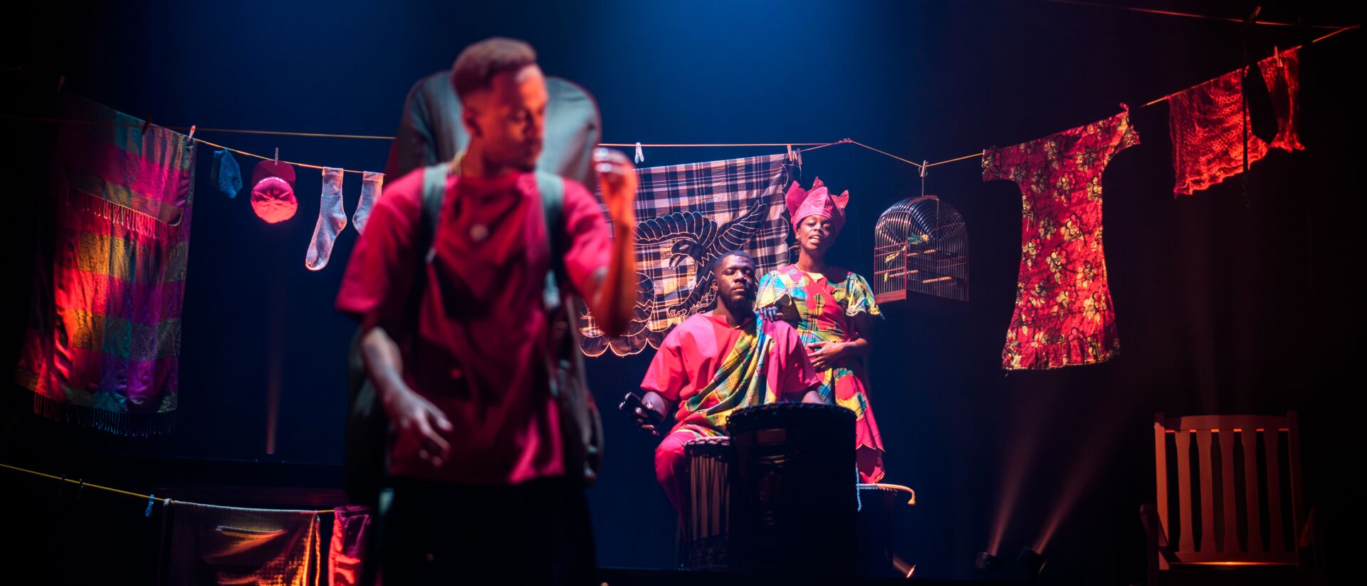 Dansers in gekleurde, traditionele gewaden staan op het podium.