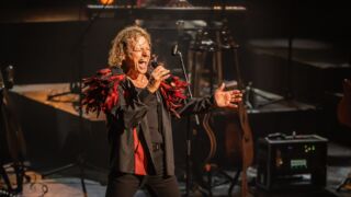 Een bandlid die zingt in een microfoon