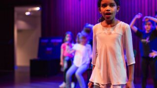 Meisje die zingt en naar rechtsboven kijkt