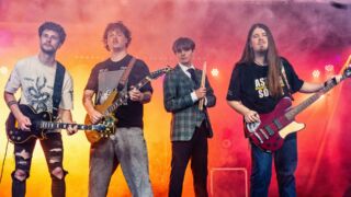 Band met vier bandleden die een instrument vasthouden