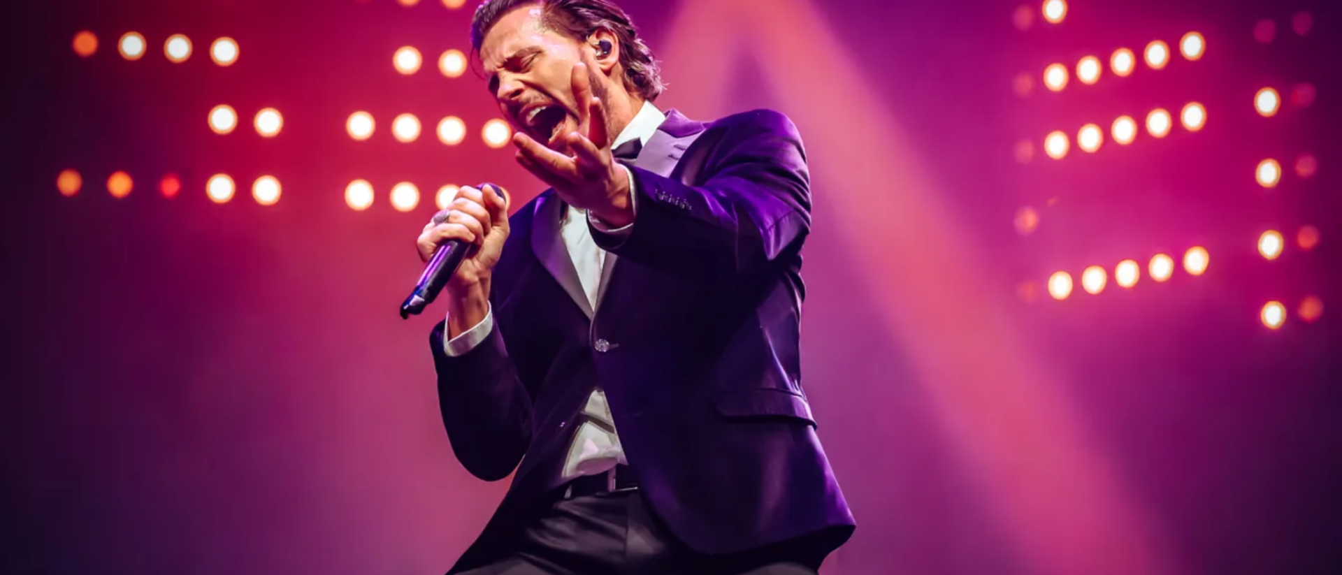 Bouke in paars pak zingt vol passie op podium tijdens Bouke Rocks Elvis Hoorn