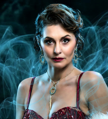Fockeline Ouwerkerk als Irene Adler in rode jurk met bontjas in Sherlock Holmes