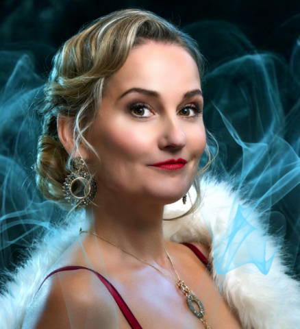 Peggy Vrijens als Irene Adler in rode jurk met bontjas in musical Sherlock Holmes
