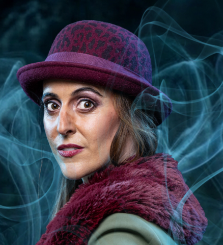 Myrthe Burger als Mary Morstan in jas en hoed omgeven door rook in Sherlock Holmes