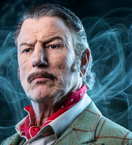 Finn Poncin als Mrs. Hudson in geruite jas met snor in musical Sherlock Holmes