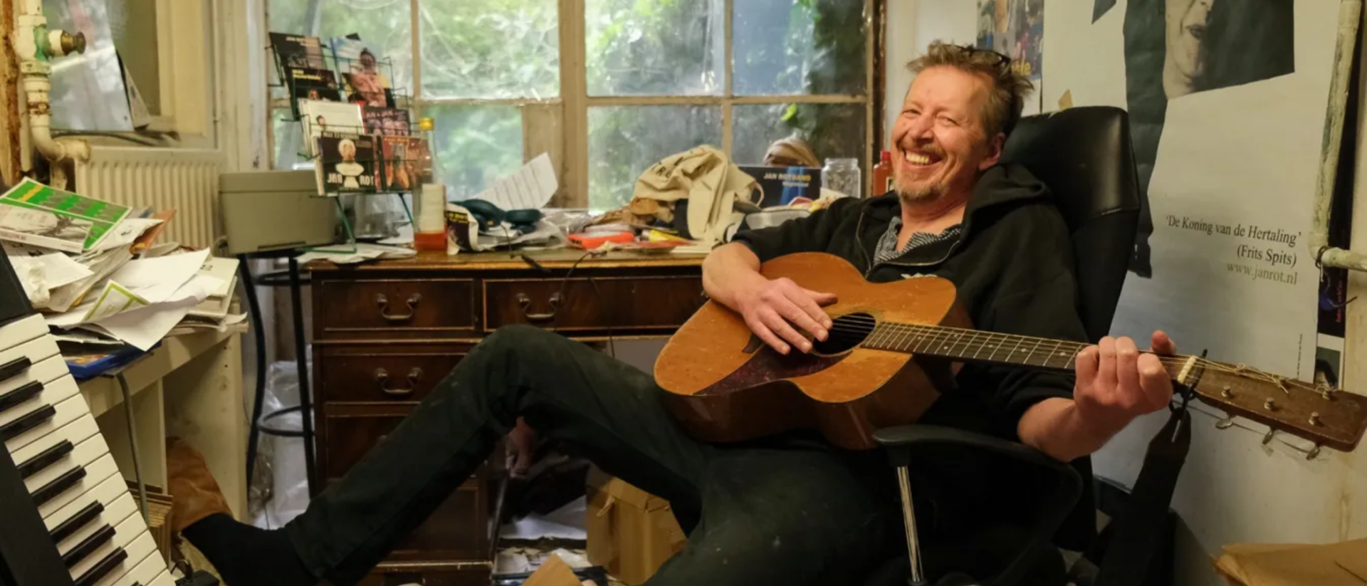 Jan Rot met gitaar in rommelig werkkamer, portretfoto voor Lievelingslijst in Hoorn