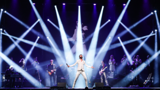 Bouke in wit pak met band op spectaculair verlicht podium tijdens Bouke Rocks Elvis Hoorn