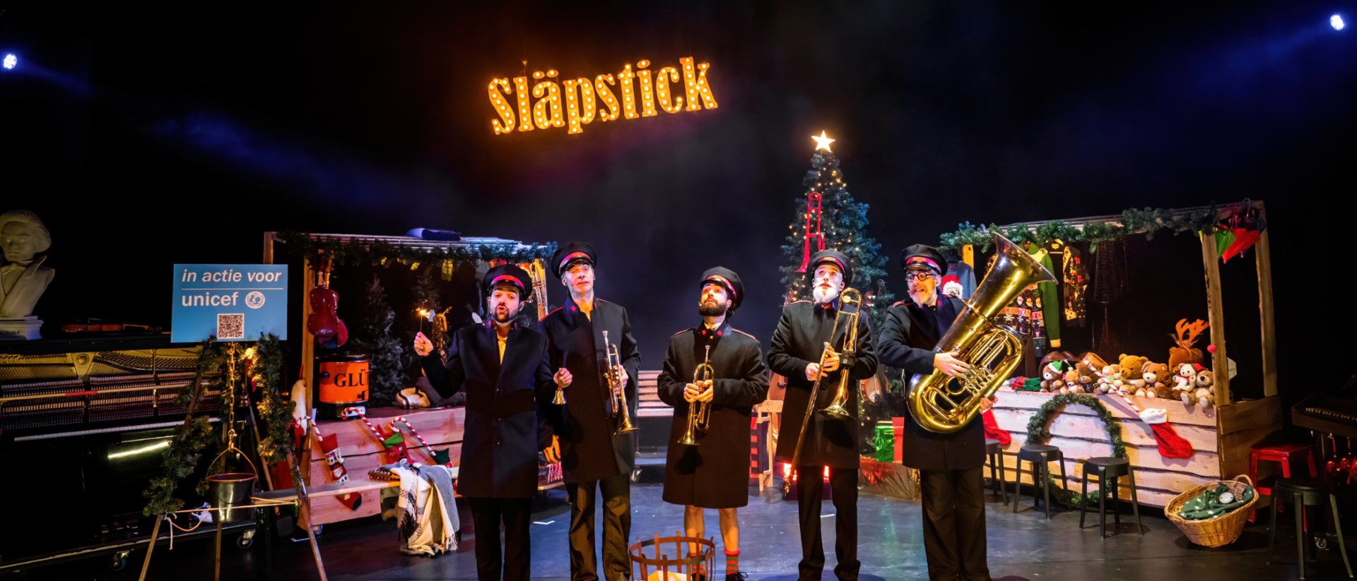 Släpstick met blaasinstrumenten op kerstpodium tijdens Ho Ho Kerstshow Hoorn