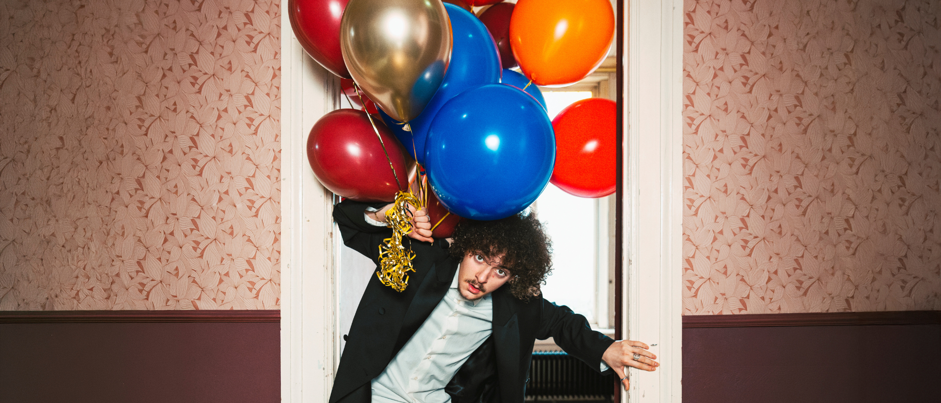 AKF finalisten tournee Amsterdams Kleinkunst Festival cabaretier met ballonnen in deuropening