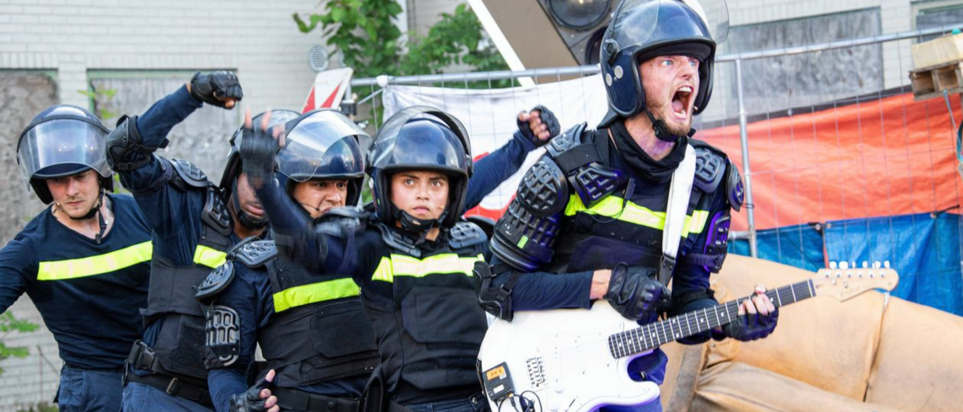 Drie dansers in politie-uitrusting tijdens acrobatische scène uit CONTRA in Hoorn