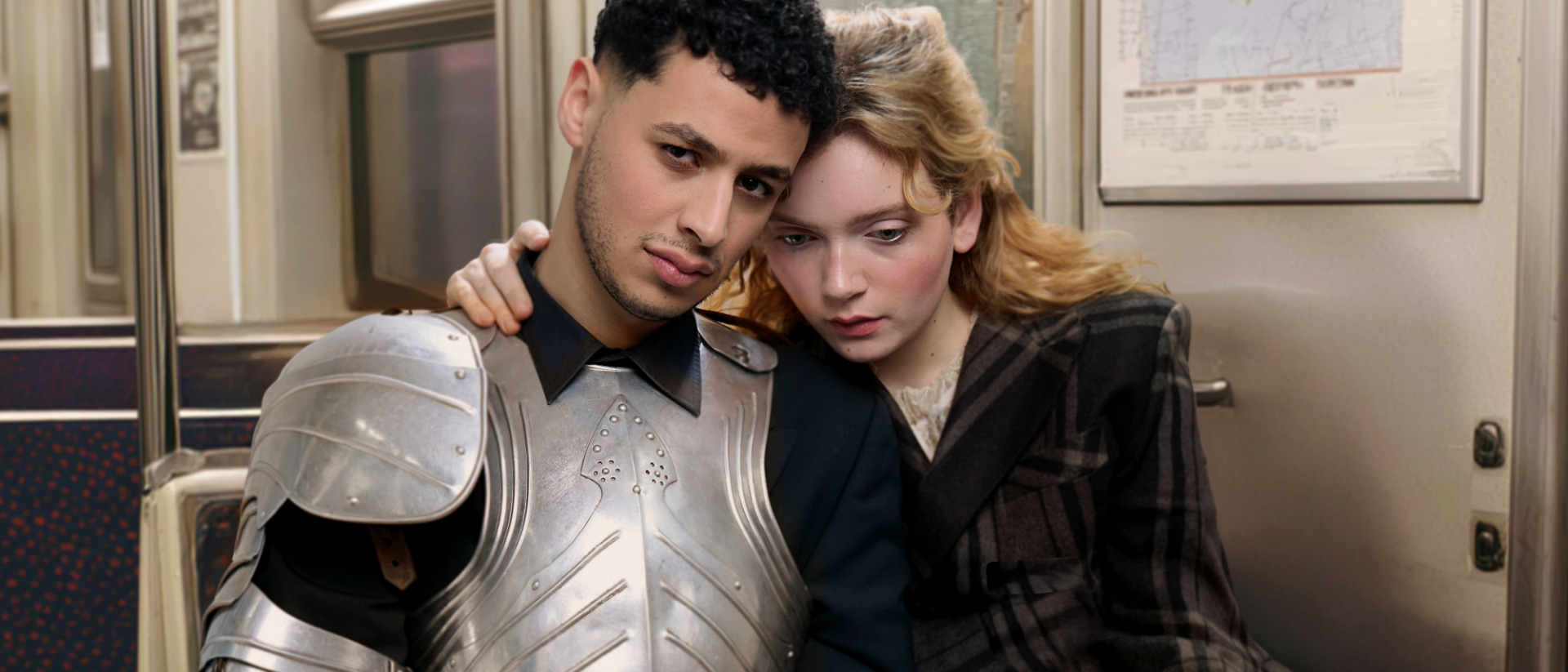 Twee acteurs als Romeo en Julia van Theater Oostpool zitten samen in een metro, hij in ridderrustingen zij in geruite jas
