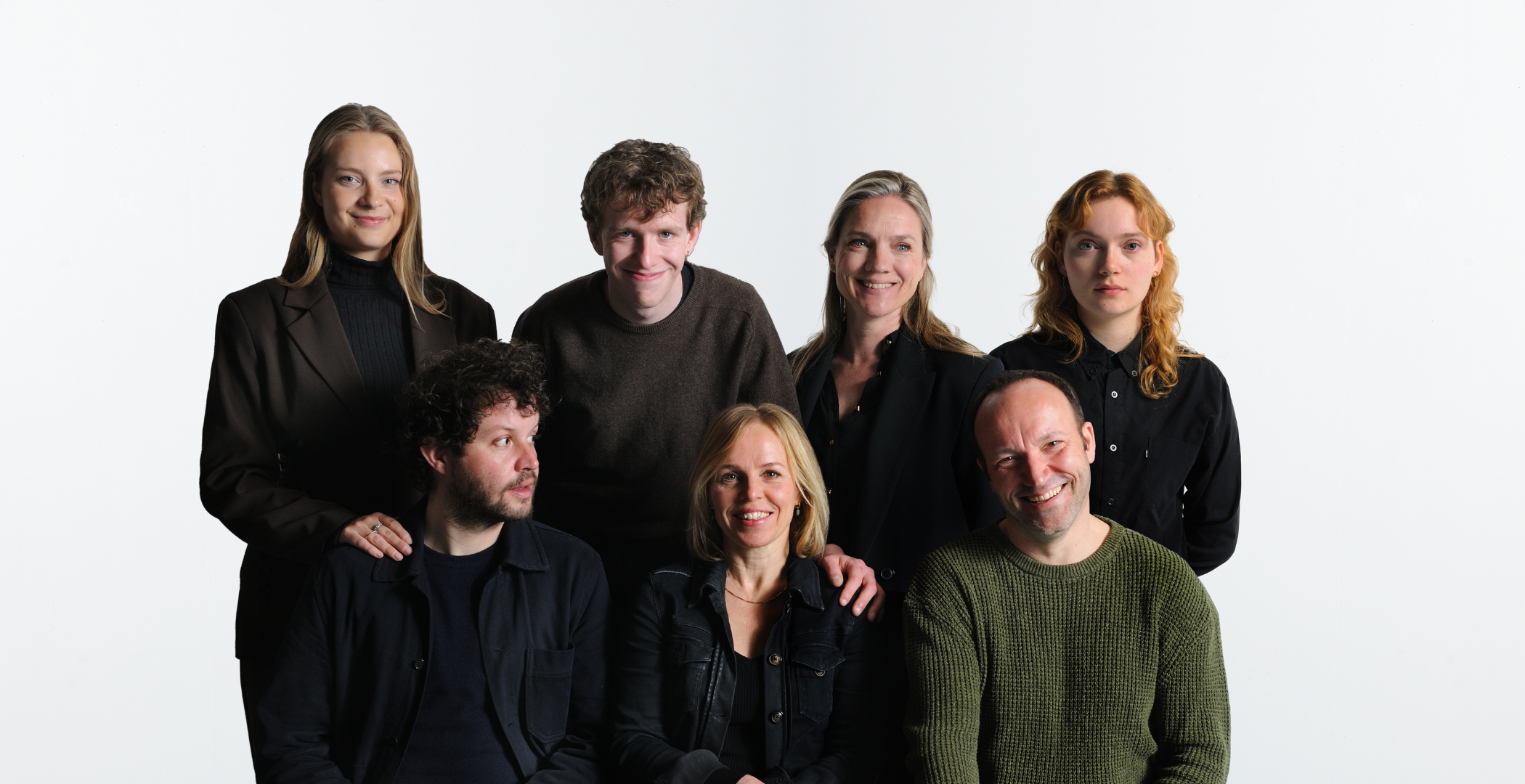 Cast Toneelgroep Maastricht De erfenis groepsfoto met zeven acteurs op witte achtergrond