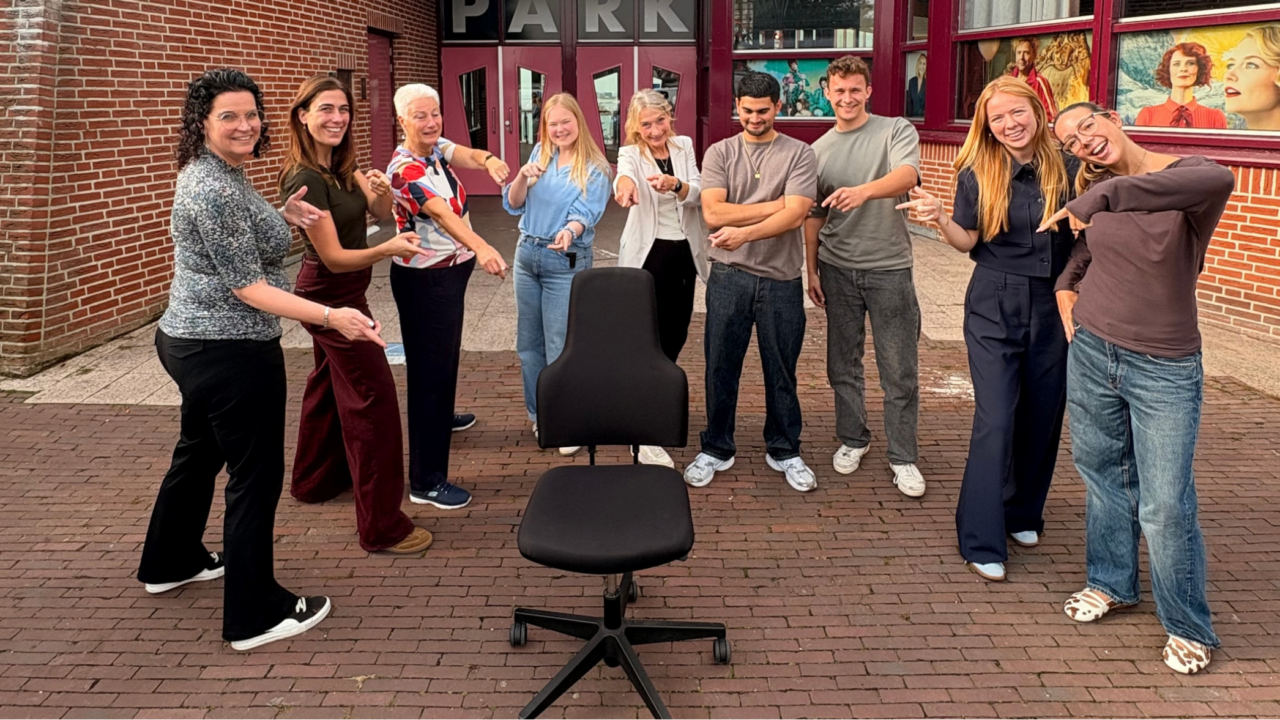 Collega's staan wijzend om een bureau stoel